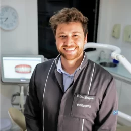 Smiling male dentist in his clinic wearing a dental coat.