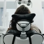 Person reclining on a dental chair.