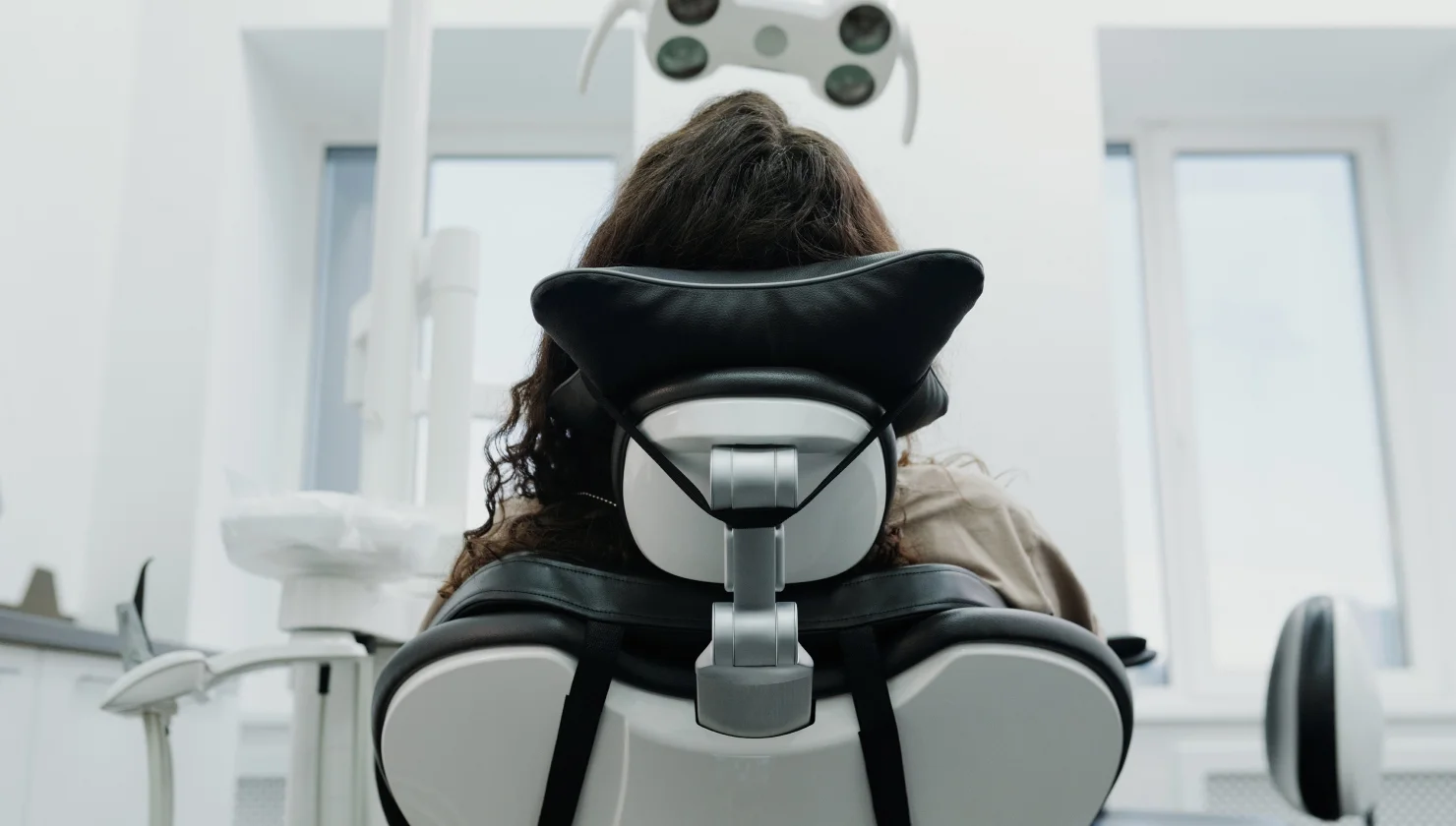 Person reclining on a dental chair.