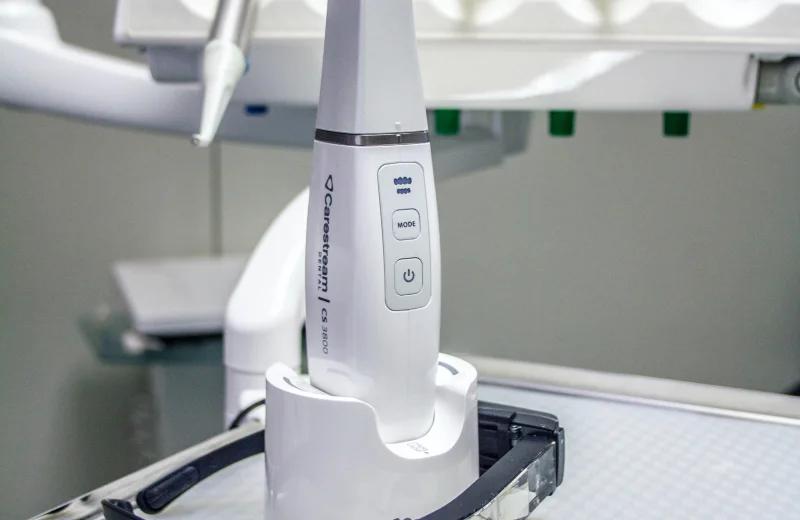 A close-up of a white dental device in a charging dock.