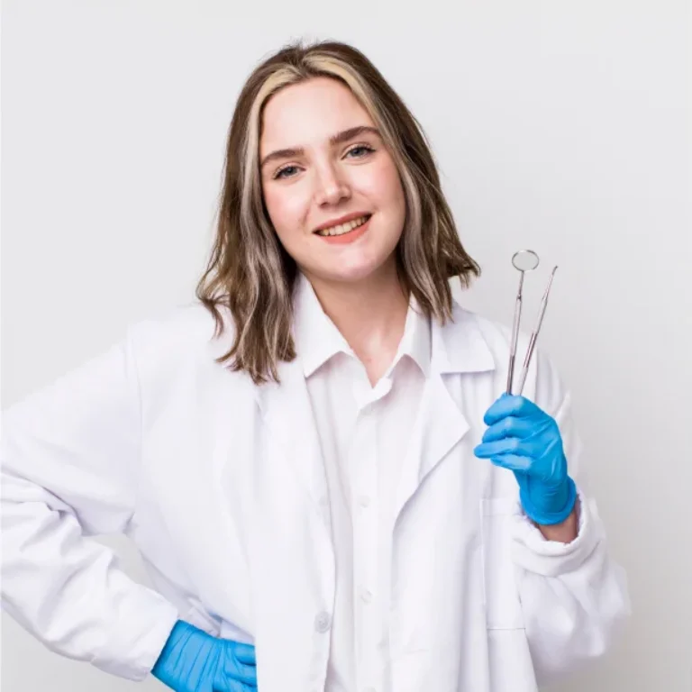 Smiling female scientist in lab coat holding glassware, wearing blue gloves.