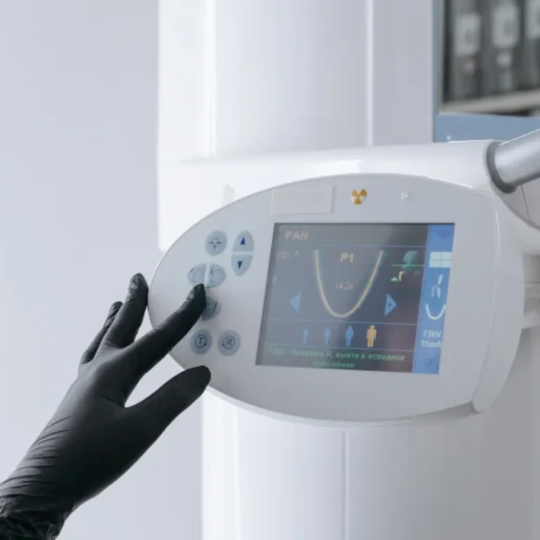 Close-up of a gloved hand interacting with a medical imaging device screen.