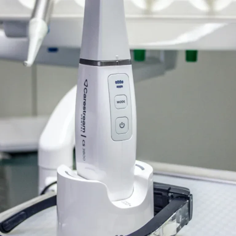 A close-up of a white dental device in a charging dock.